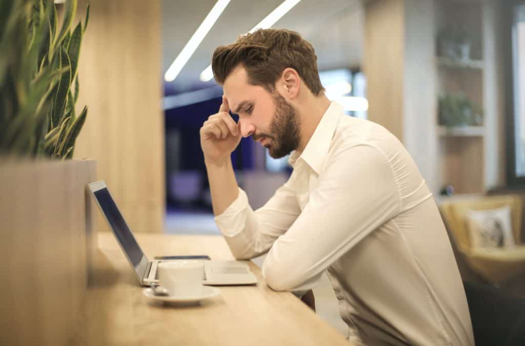 alt="man intently looking at his laptop screen figuring out how to deal with an issue."