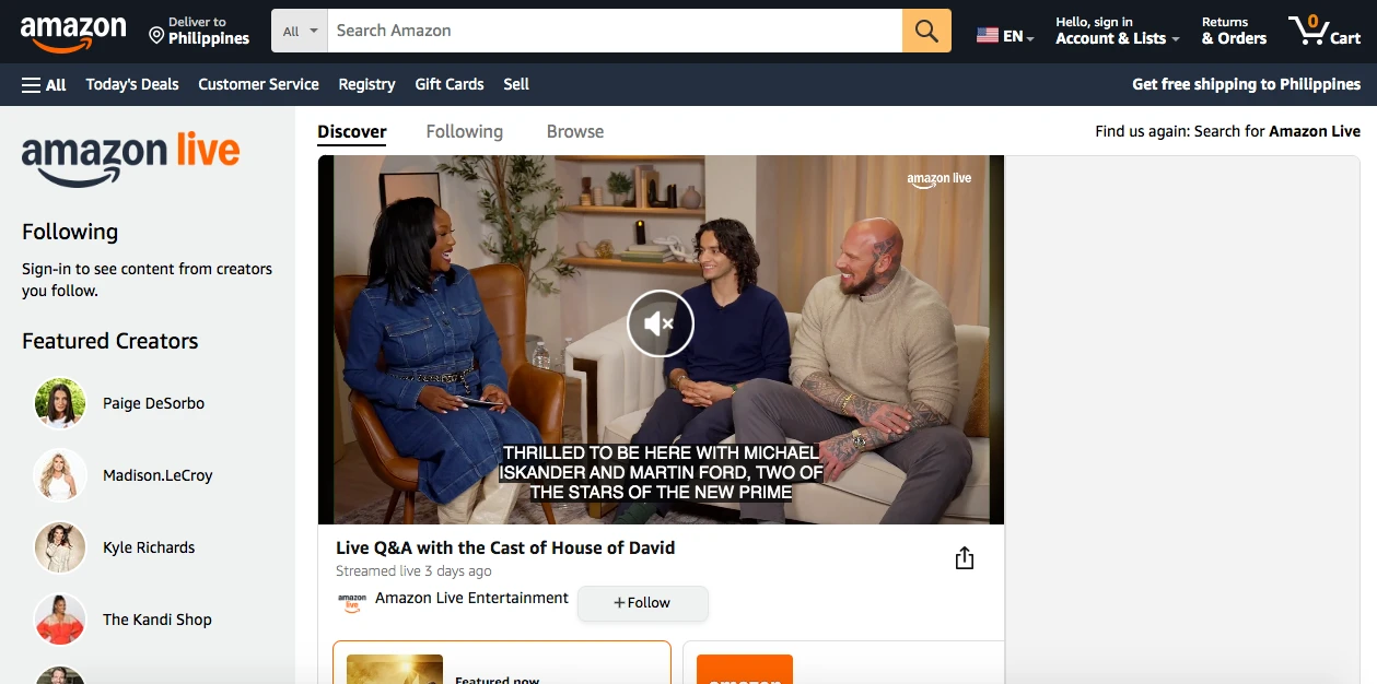 A screenshot of Amazon Live featuring a Q&A session. Three people sit on a sofa, smiling and chatting. The screen displays subtitles. The Amazon Live interface shows options like Discover, Following, and Featured Creators on the left.