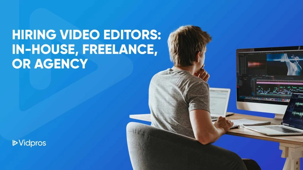 A person in a gray shirt sits at a desk using a laptop, focused on dual monitors with video editing software. The blue background announces: Hiring Video Editors: In-House, Freelance, Agency. Vidpros logo graces the corner, showcasing their top-notch video editing services for content creators.
