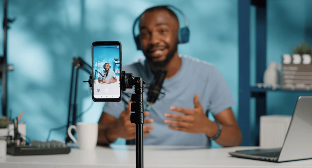 alt="male video content creator recording a video for posting online""