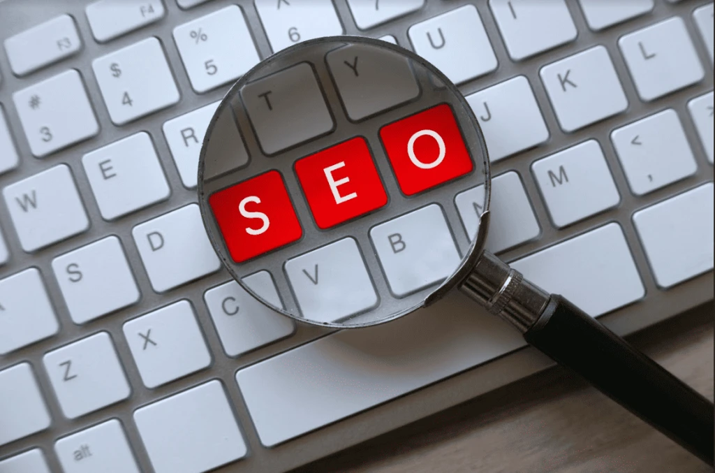 alt="magnified SEO typeface on laptop keyboard emphasizing on content topics"