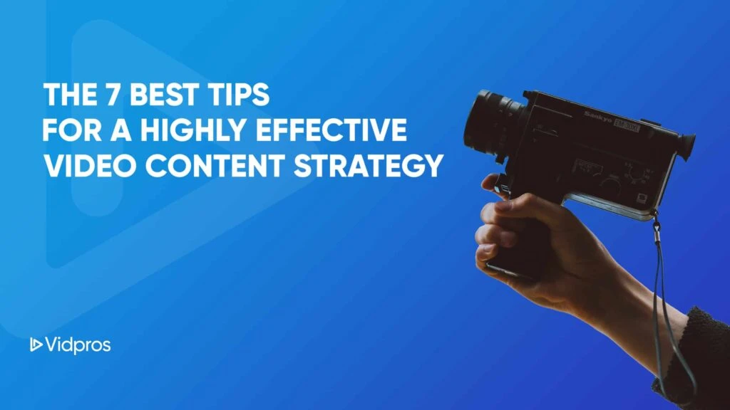 alt="image of a hand holding a video camera in a blue background"