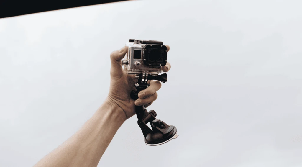 alt="man taking a selfie shot using a GoPro action camera"